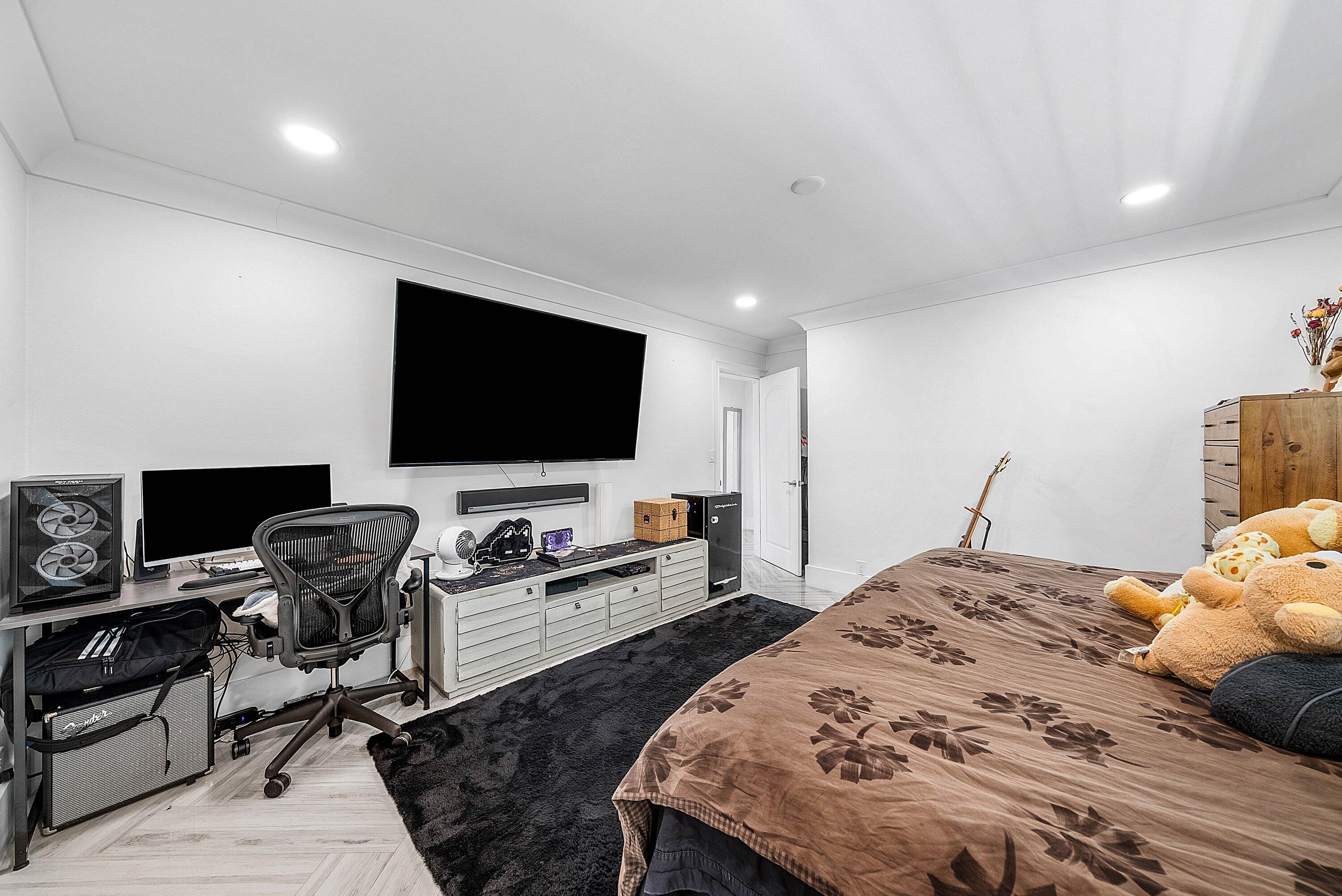 7425 Northeast Bay Cove Court Boca Raton, FL 33487 - Photo 53 of 86 a bedroom with a bed and a flat screen tv