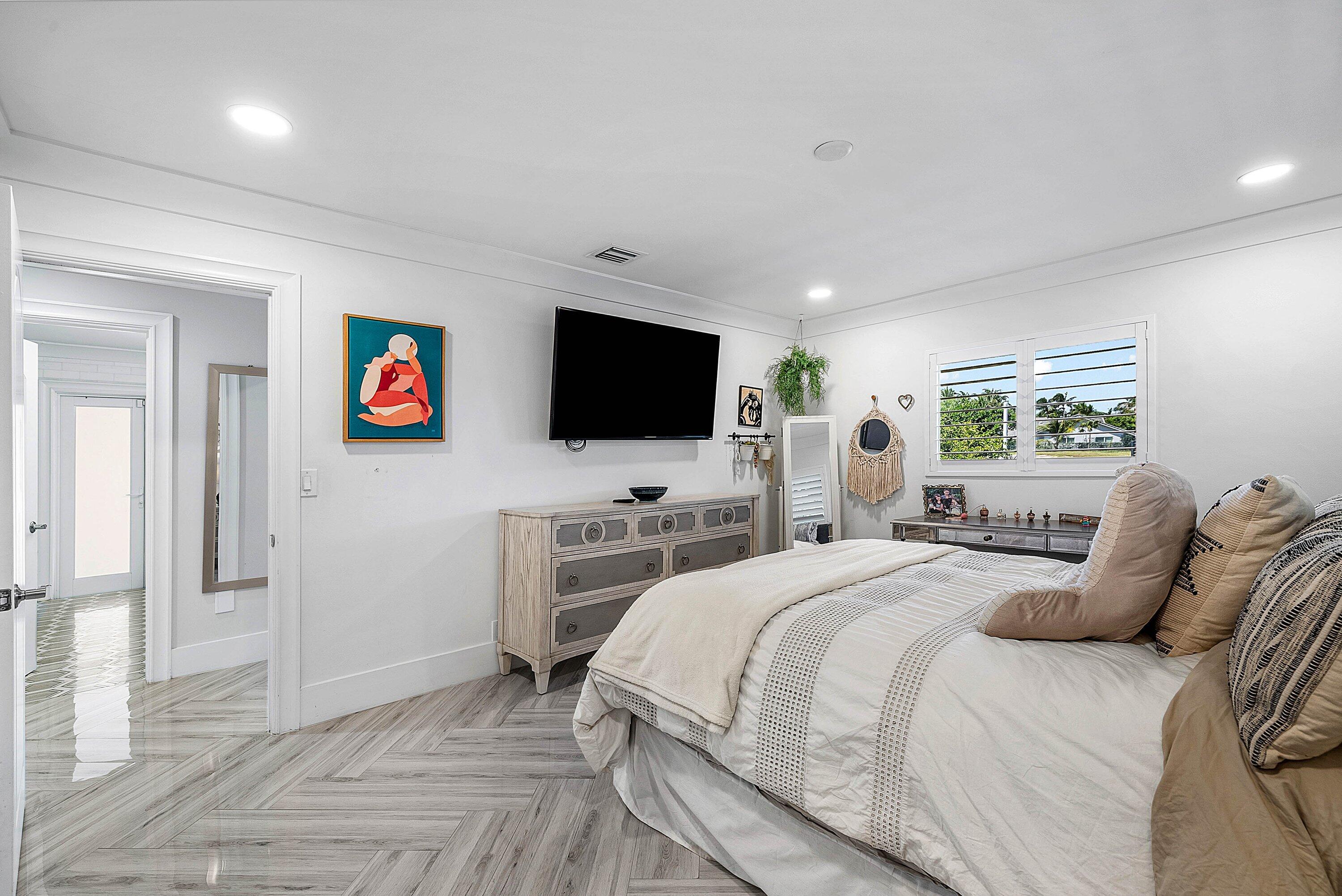 7425 Northeast Bay Cove Court Boca Raton, FL 33487 - Photo 55 of 86 a bedroom with a bed and a flat screen tv