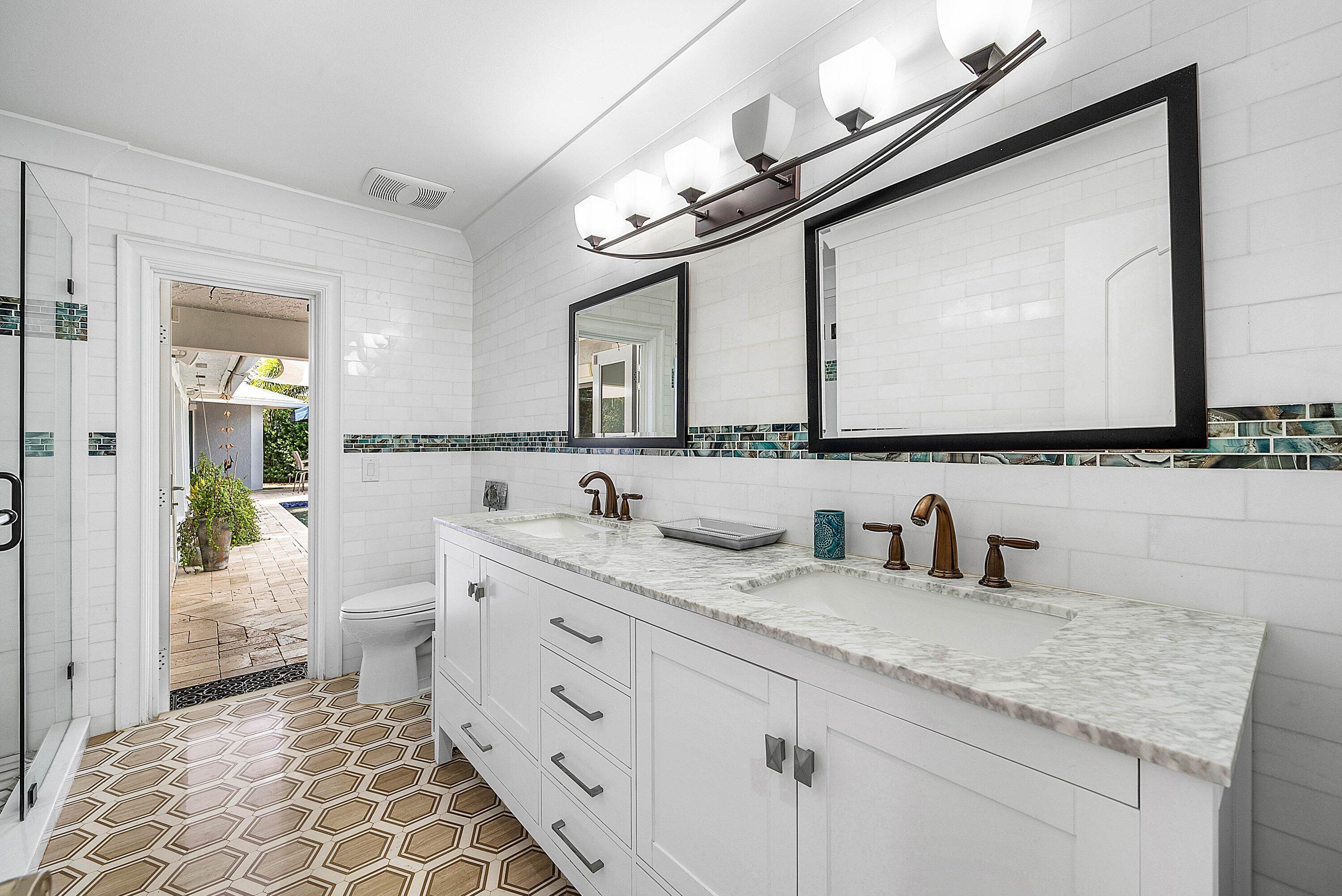 7425 Northeast Bay Cove Court Boca Raton, FL 33487 - Photo 57 of 86 a bathroom with a granite countertop sink mirror and a