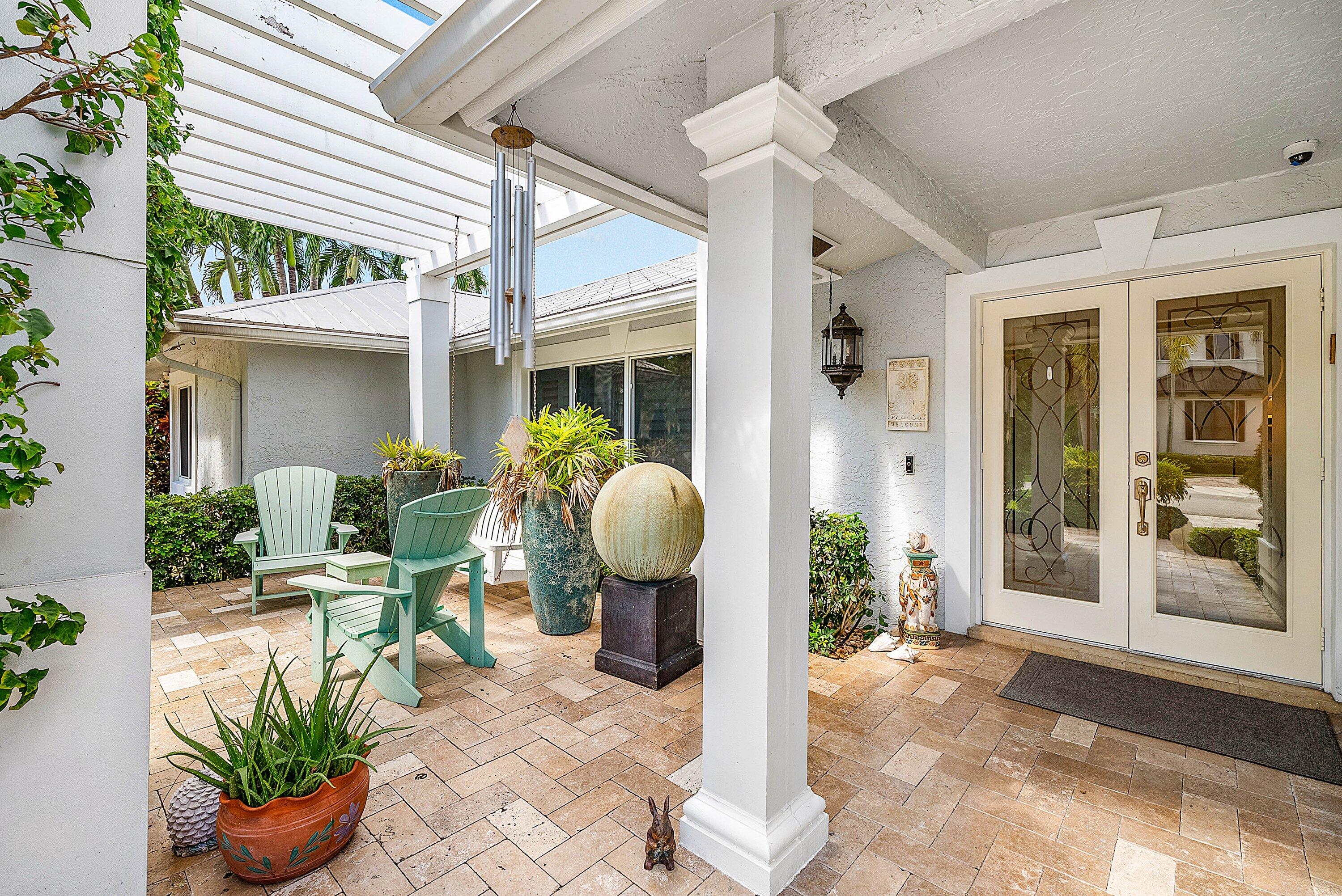 7425 Northeast Bay Cove Court Boca Raton, FL 33487 - Photo 6 of 86 a view of a patio with table and chairs potted plants