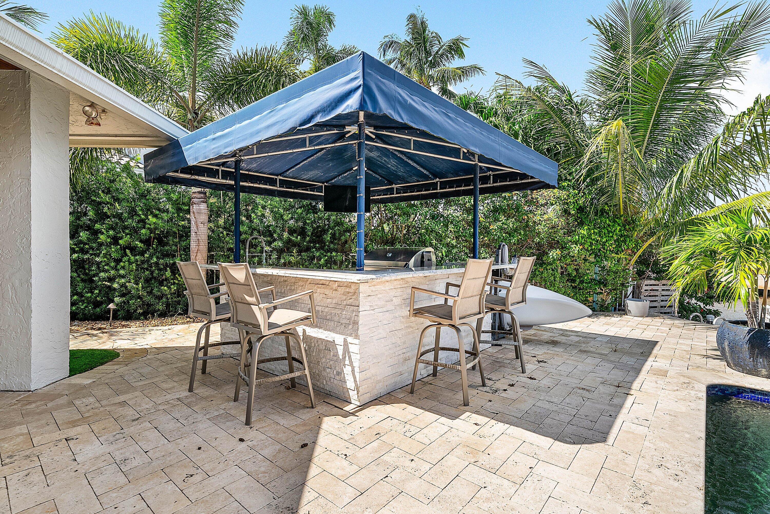7425 Northeast Bay Cove Court Boca Raton, FL 33487 - Photo 67 of 86 a view of patio with table and chairs under an umbrella