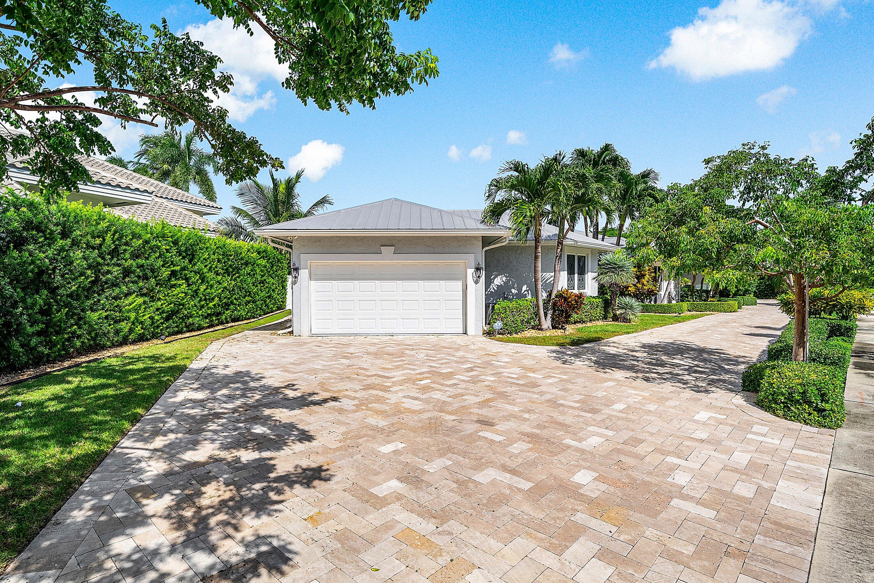 7425 Northeast Bay Cove Court Boca Raton, FL 33487 - Photo 86 of 86 a front view of a house with a yard and trees