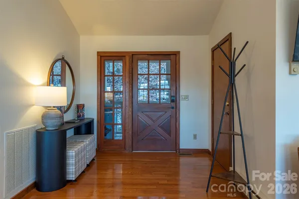 a living room with furniture a dining table and a floor to ceiling window