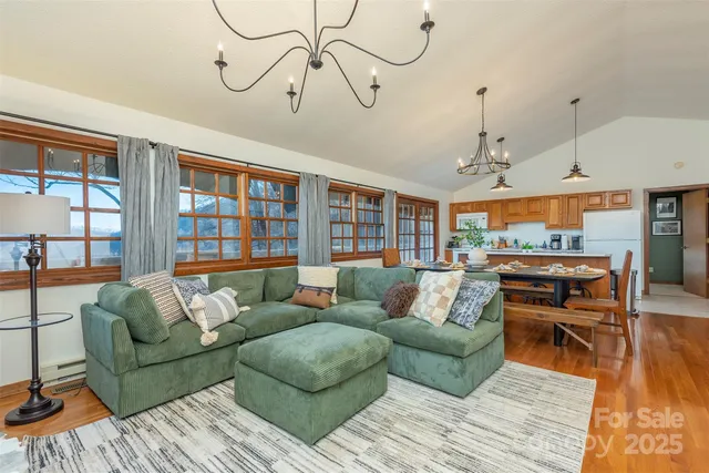 a living room with furniture a dining table and a floor to ceiling window