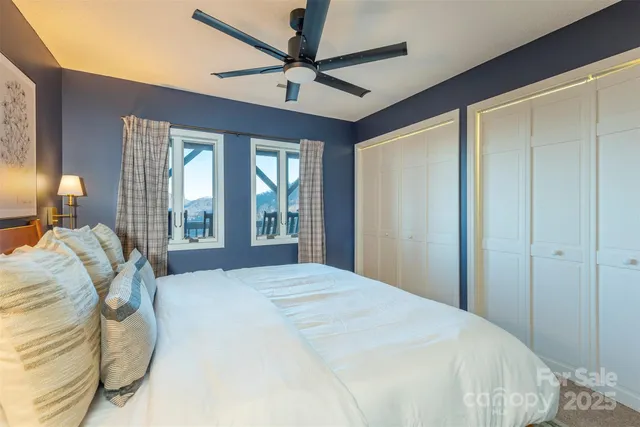 a bedroom with a bed ceiling fan and a window