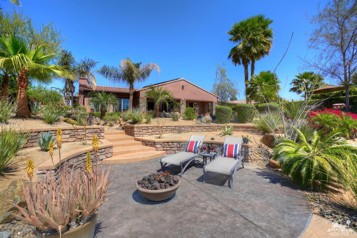 5 Via Santa Velera Rancho Mirage, CA 92270 - Photo 12 of 90 a patio with a table and chairs under an umbrella with potted plants