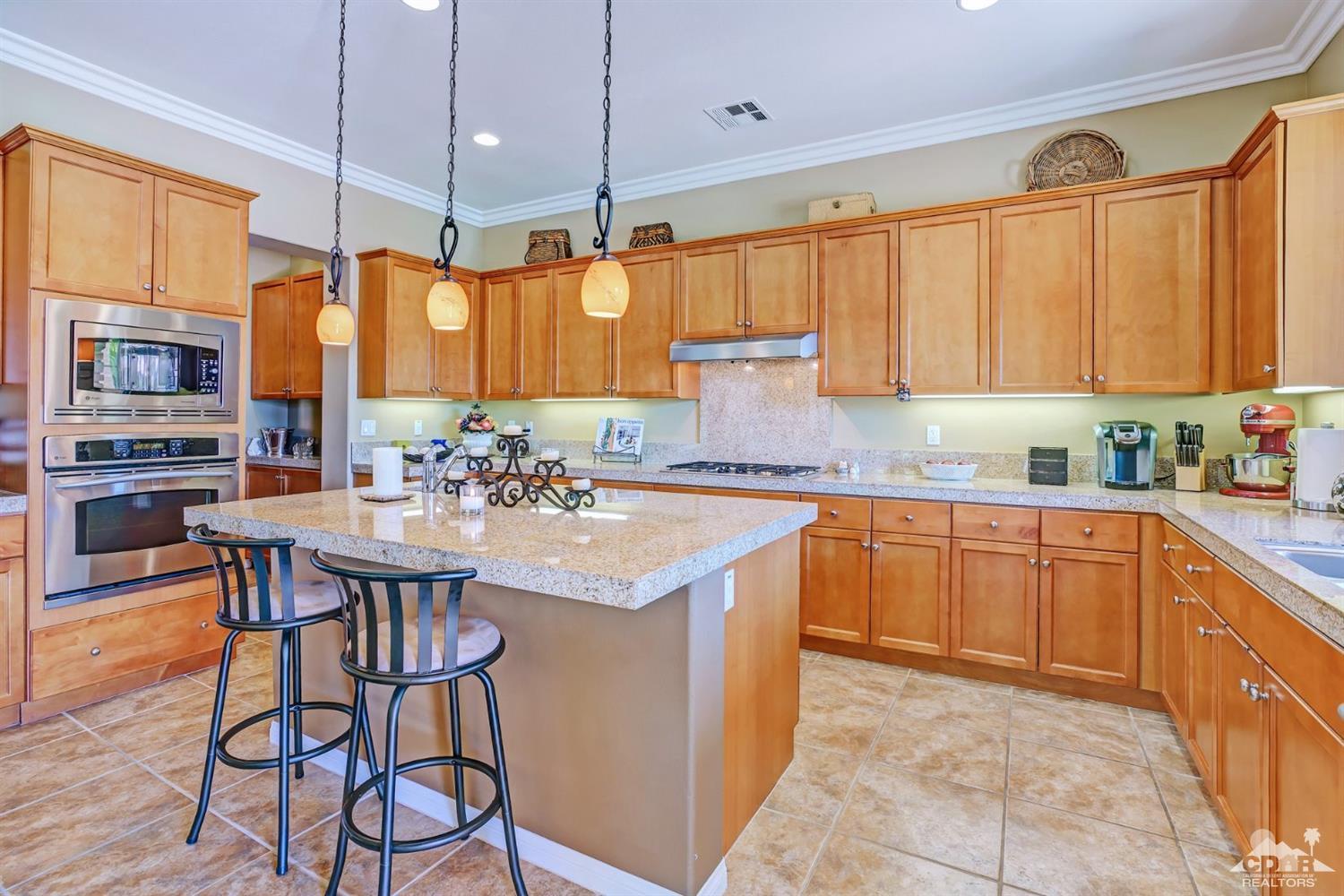 5 Via Santa Velera Rancho Mirage, CA 92270 - Photo 37 of 90 a kitchen with stainless steel appliances granite countertop a stove a sink dishwasher and a refrigerator with wooden cabinets