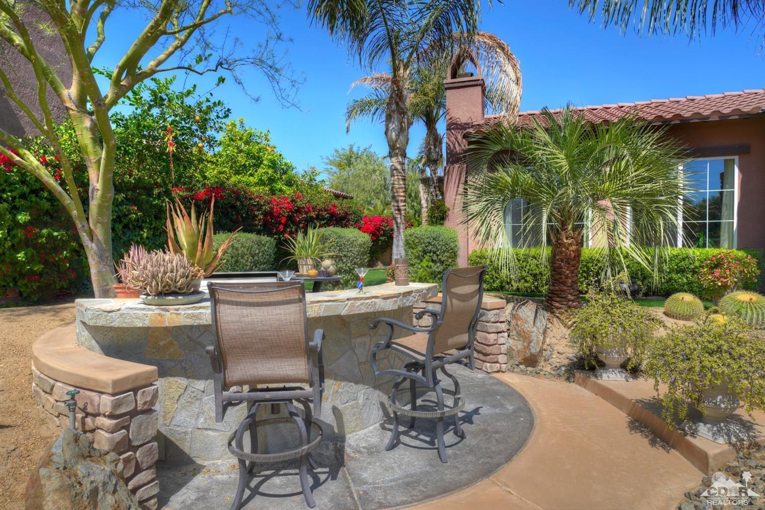 5 Via Santa Velera Rancho Mirage, CA 92270 - Photo 87 of 90 a view of a patio with table and chairs potted plants and palm tree
