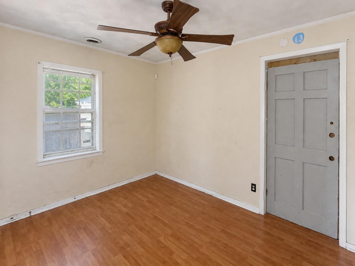Wood-finish flooring with neutral wall tones and a ceiling fan