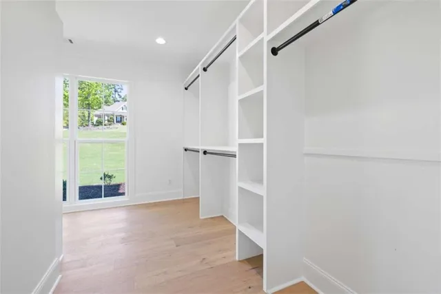 a view of an empty room with chandelier fan and window