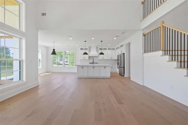 a large kitchen with stainless steel appliances kitchen island granite countertop a sink and cabinets