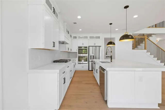 a view of an empty room with a window and a kitchen