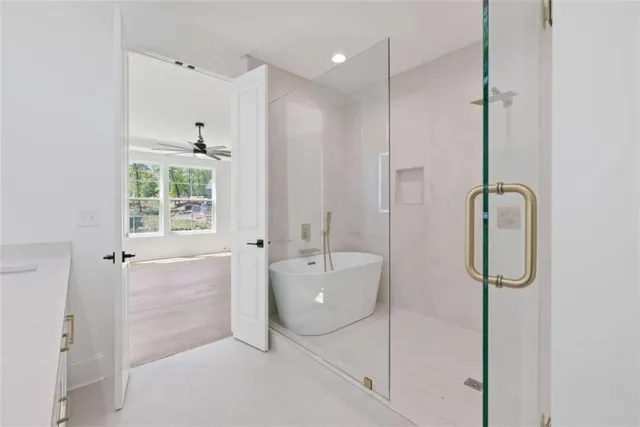 a kitchen with stainless steel appliances granite countertop a stove a sink a refrigerator and white cabinets with wooden floor