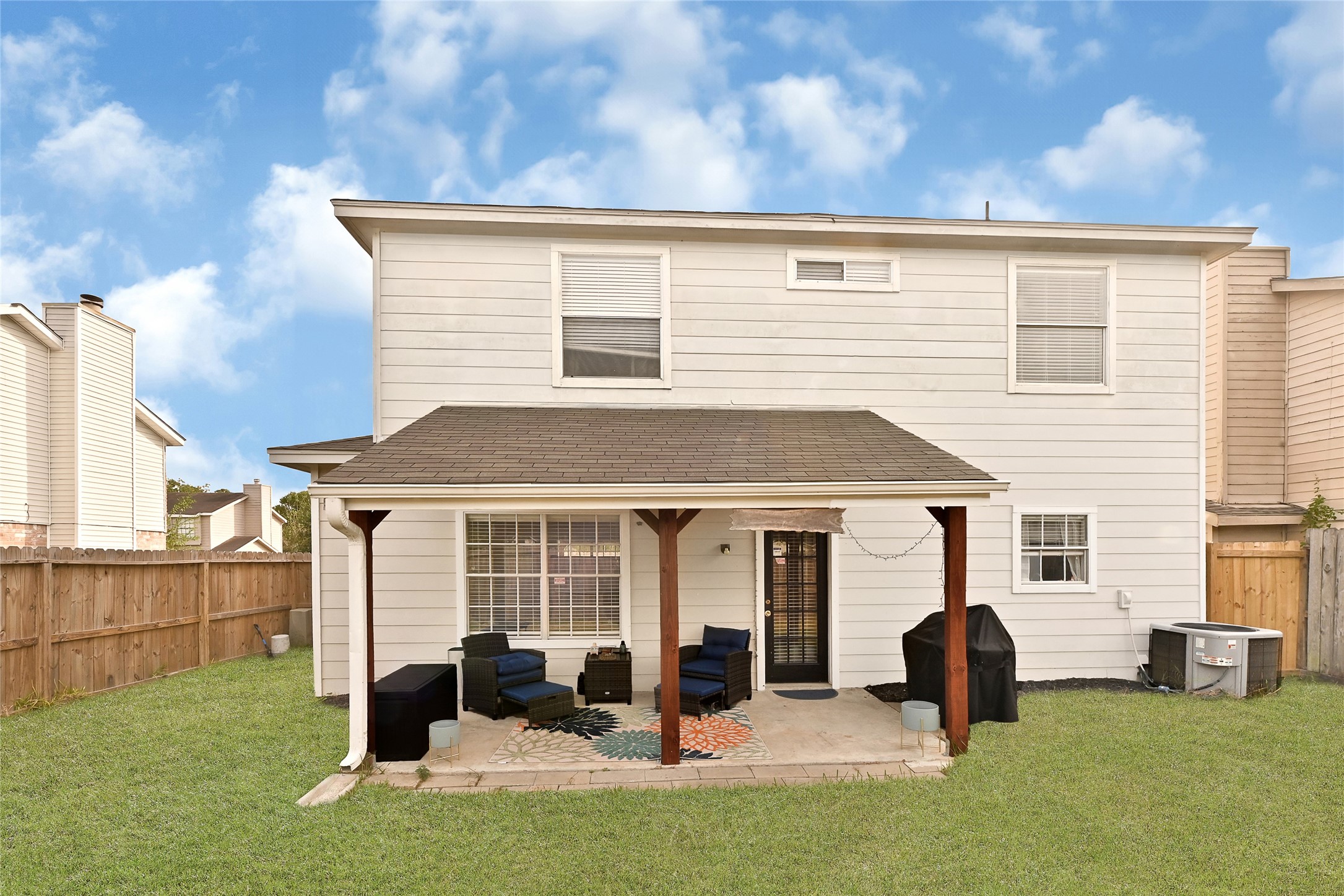 10100 Spring Pl Drive Houston, TX 77070 - Photo 24 of 24 Rear exterior view showcasing the covered patio and fully fenced yard for added privacy.