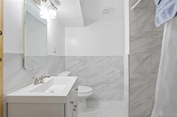 a bathroom with a sink a toilet and mirror