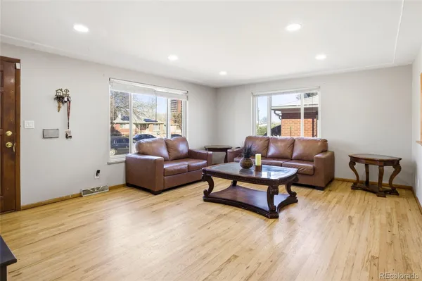 a living room with furniture and a wooden floor