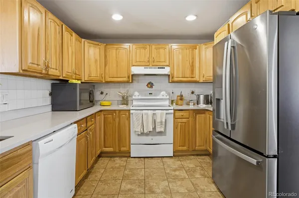 a kitchen with a refrigerator sink and cabinets