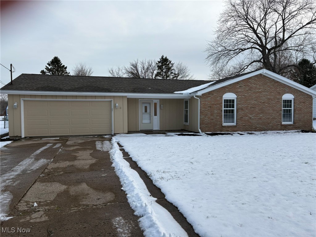Ranch-style house with brick siding, driveway, covered porch, an attached garage, and roof with shingles