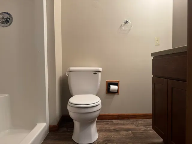 a bathroom with a toilet a sink and mirror