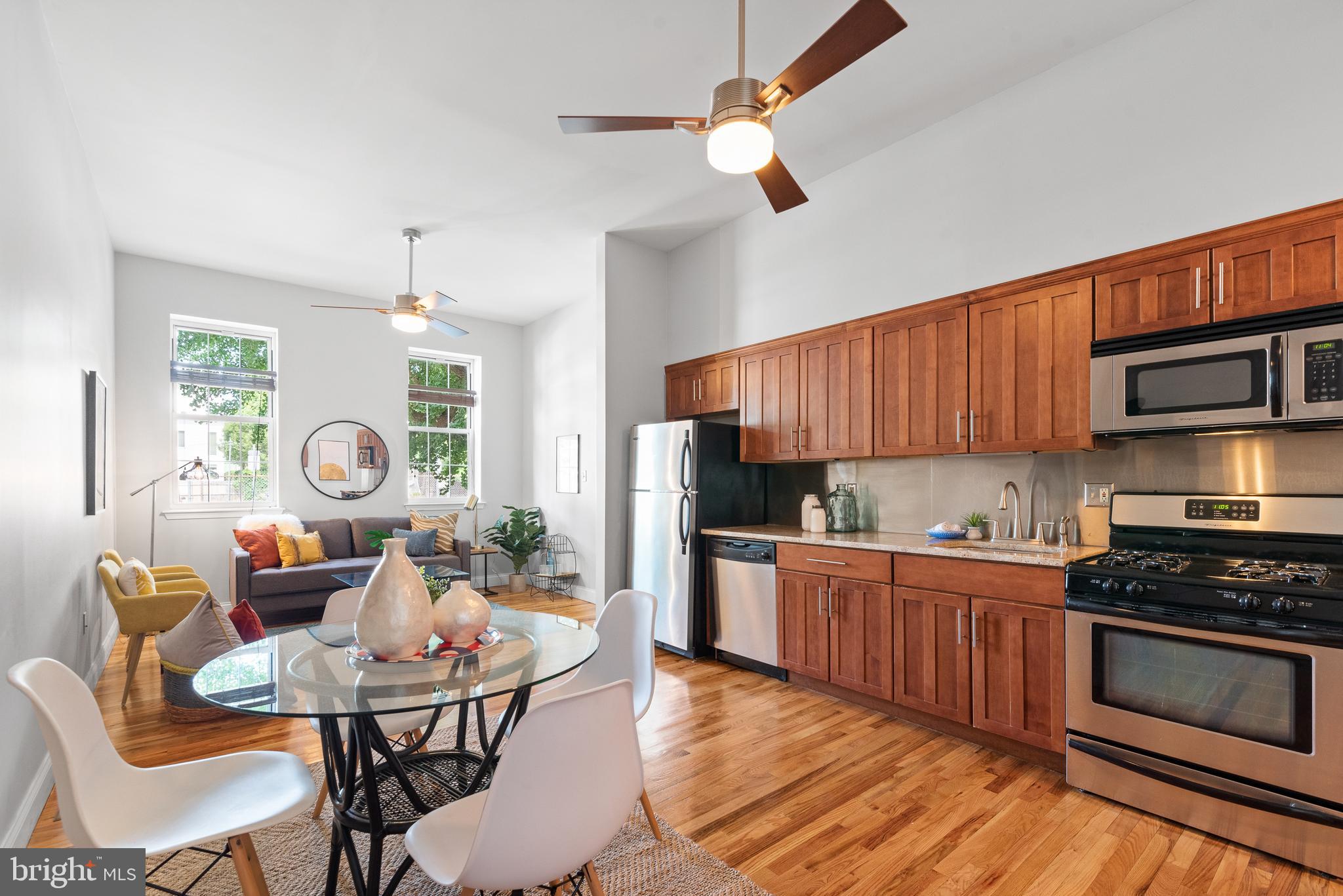 997 North 6th Street, Unit 1 Philadelphia, PA 19123 - Photo 1 of 28 a kitchen with stainless steel appliances a stove a sink dishwasher a dining table and chairs with wooden floor