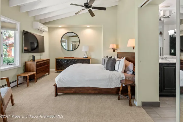 a spacious bedroom with a bed a mirror and a desk