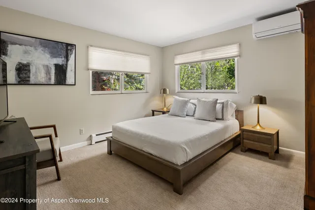 a bedroom with a bed table and window