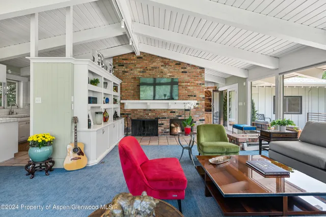 a living room with furniture a fireplace and potted plants