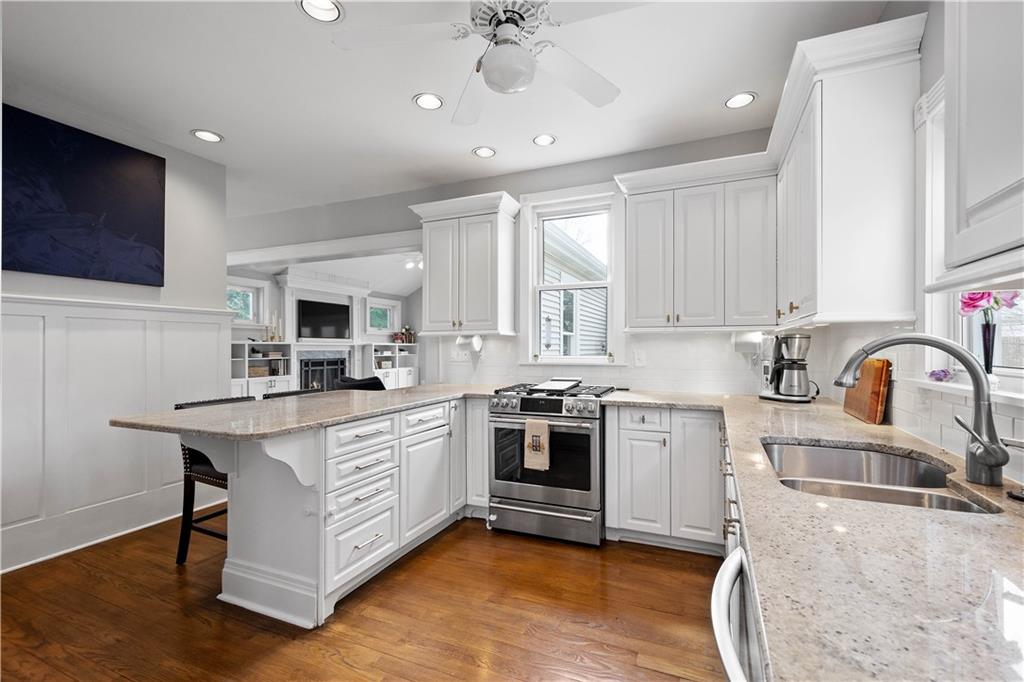 419 Oliver Road Sewickley, PA 15143 - Photo 10 of 34 a kitchen with stainless steel appliances granite countertop a stove top oven a sink dishwasher and white cabinets with wooden floor