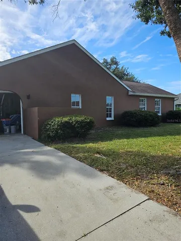 a backyard of a house with plants and barbeque oven