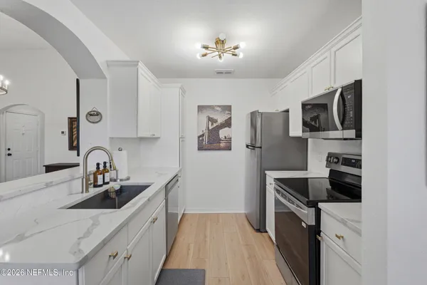 a kitchen with a sink appliances and cabinets