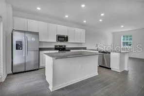 a kitchen with stainless steel appliances a refrigerator stove microwave and sink