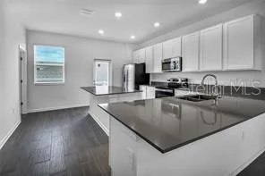 a kitchen with stainless steel appliances granite countertop a sink a stove top oven a counter space and cabinets