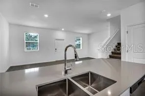 a kitchen with kitchen island a sink stainless steel appliances and window