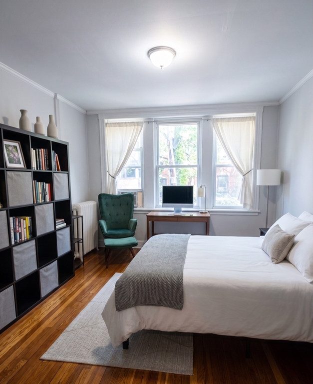 98 Strathmore Road, Unit 2 Boston, MA 02135 - Photo 2 of 11 a bedroom with a bed a dresser and a large window
