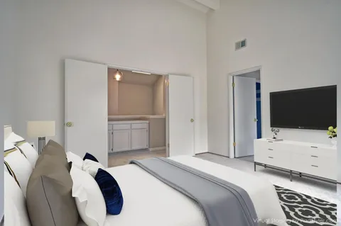 a bedroom with a bed and a flat screen tv