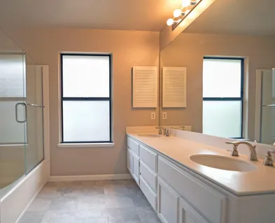 a bathroom with a double vanity sink and a window