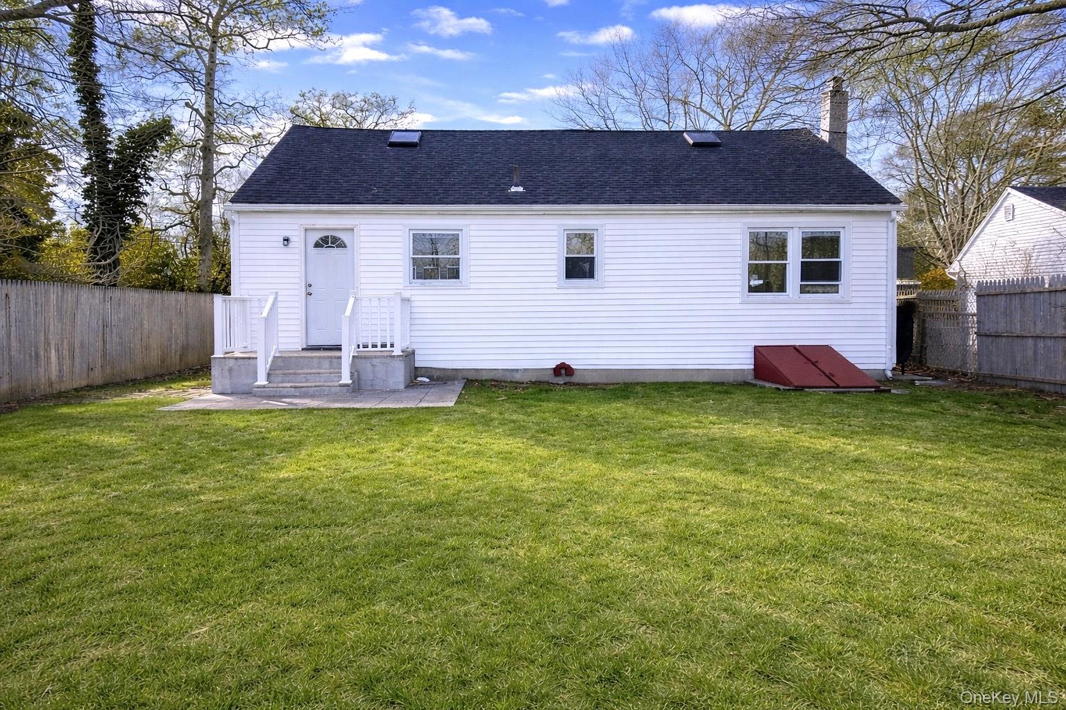 79 Johns Neck Road Shirley, NY 11967 - Photo 8 of 11 a front view of a house with a garden and yard