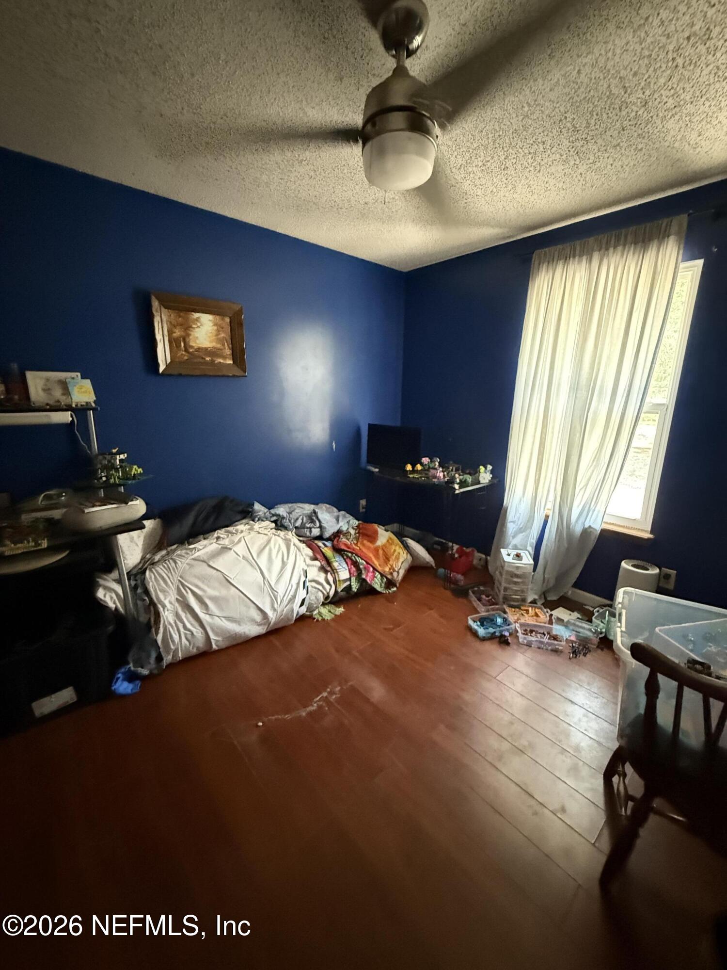 45 Mint Circle Middleburg, FL 32068 - Photo 14 of 24 a bedroom with a bed and dresser with wooden floor