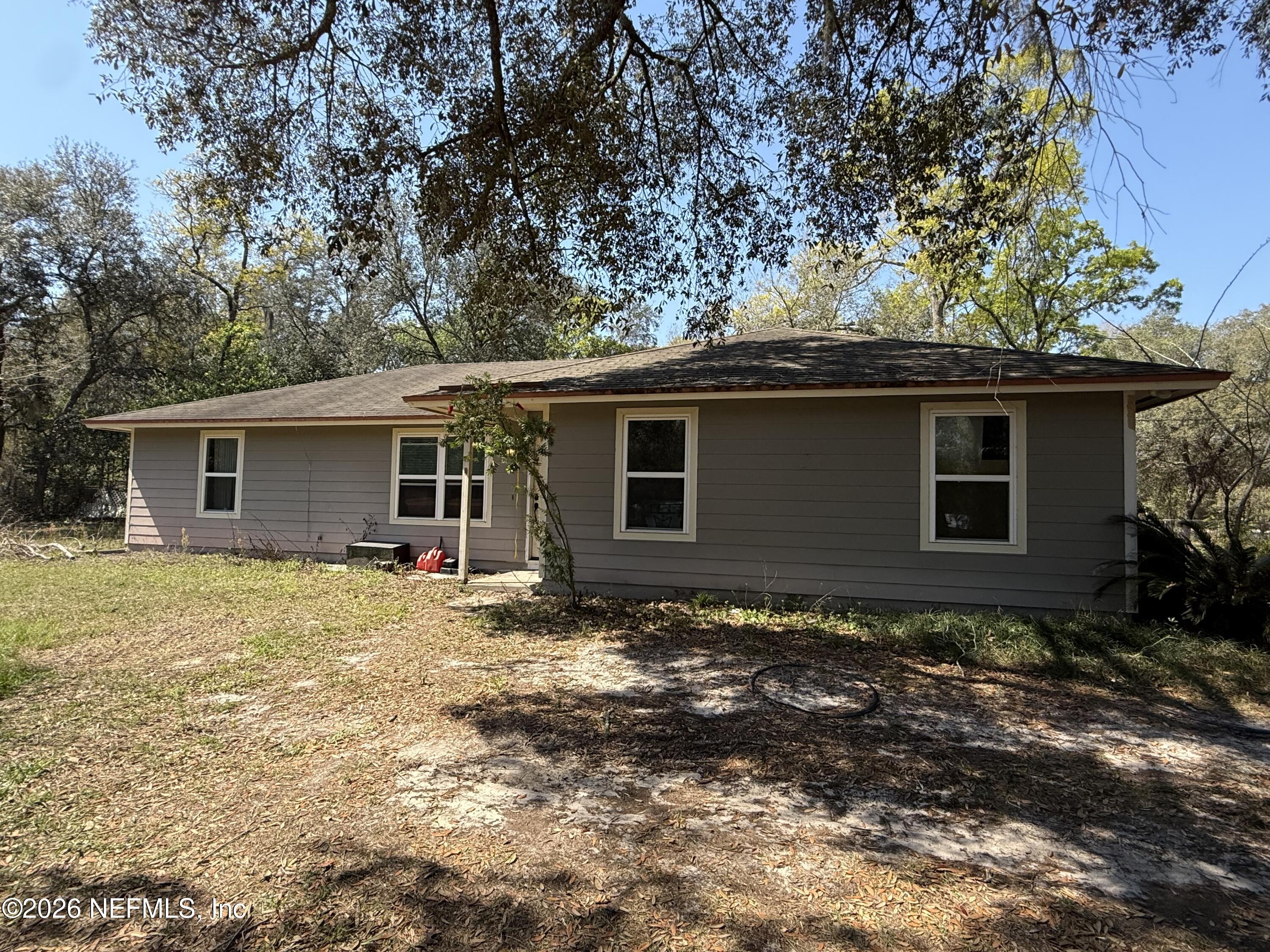 45 Mint Circle Middleburg, FL 32068 - Photo 3 of 24 a backyard of a house with large trees and barbeque oven