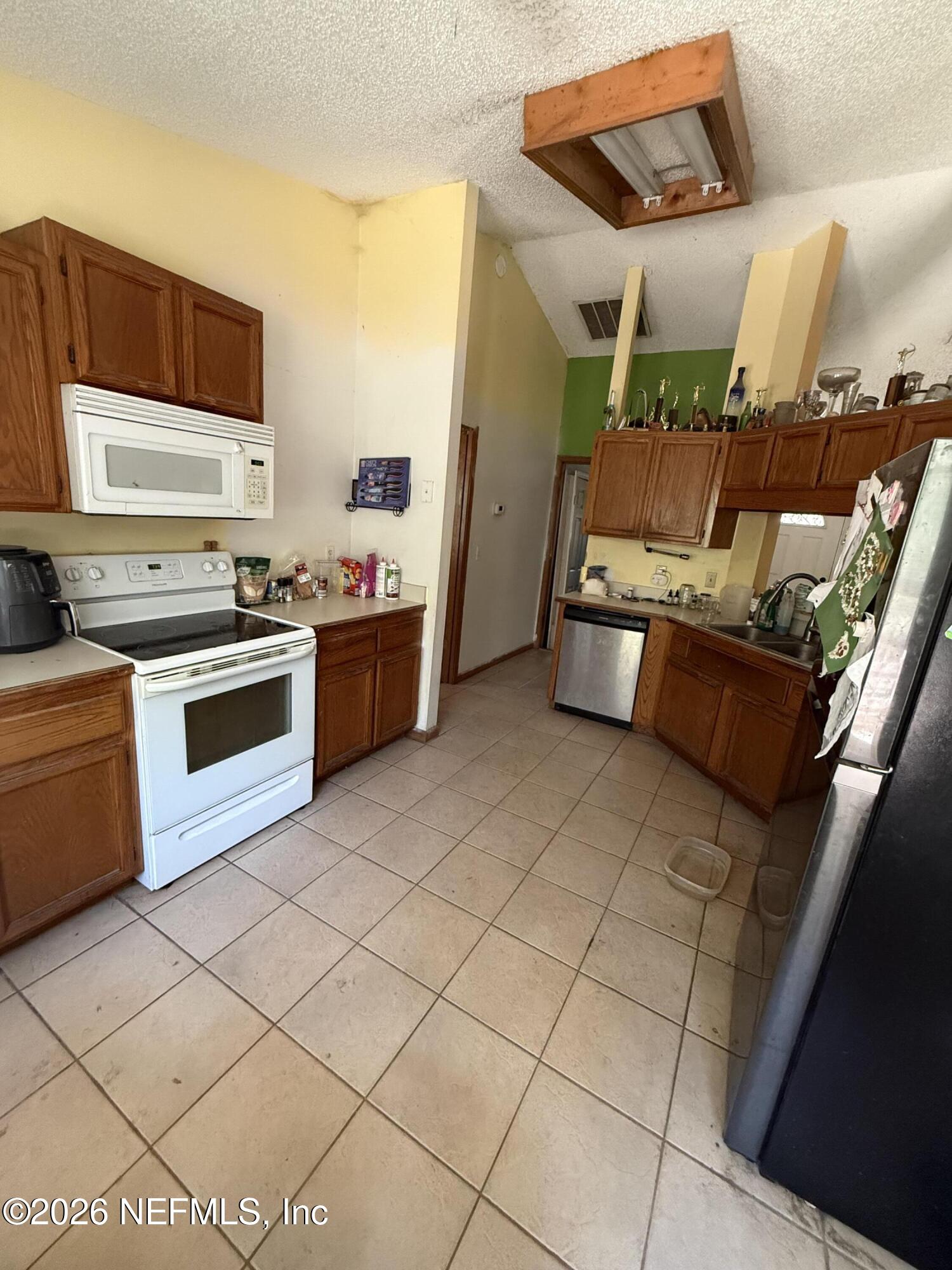 45 Mint Circle Middleburg, FL 32068 - Photo 4 of 24 a kitchen with stainless steel appliances a stove a sink and a refrigerator
