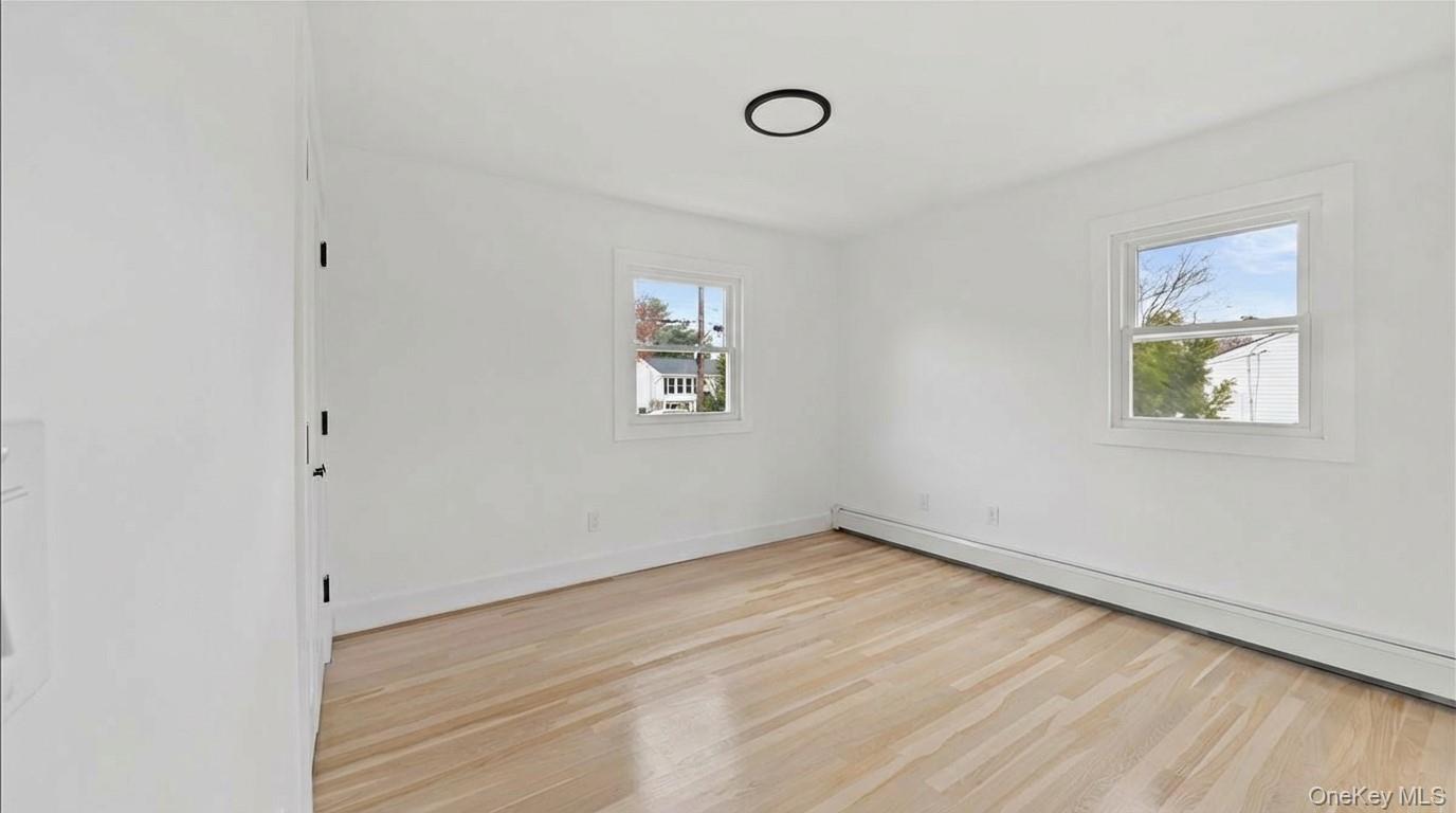 77 Friendly Road Mahopac, NY 10541 - Photo 19 of 36 Second bedroom featuring light wood-style flooring and baseboard heating