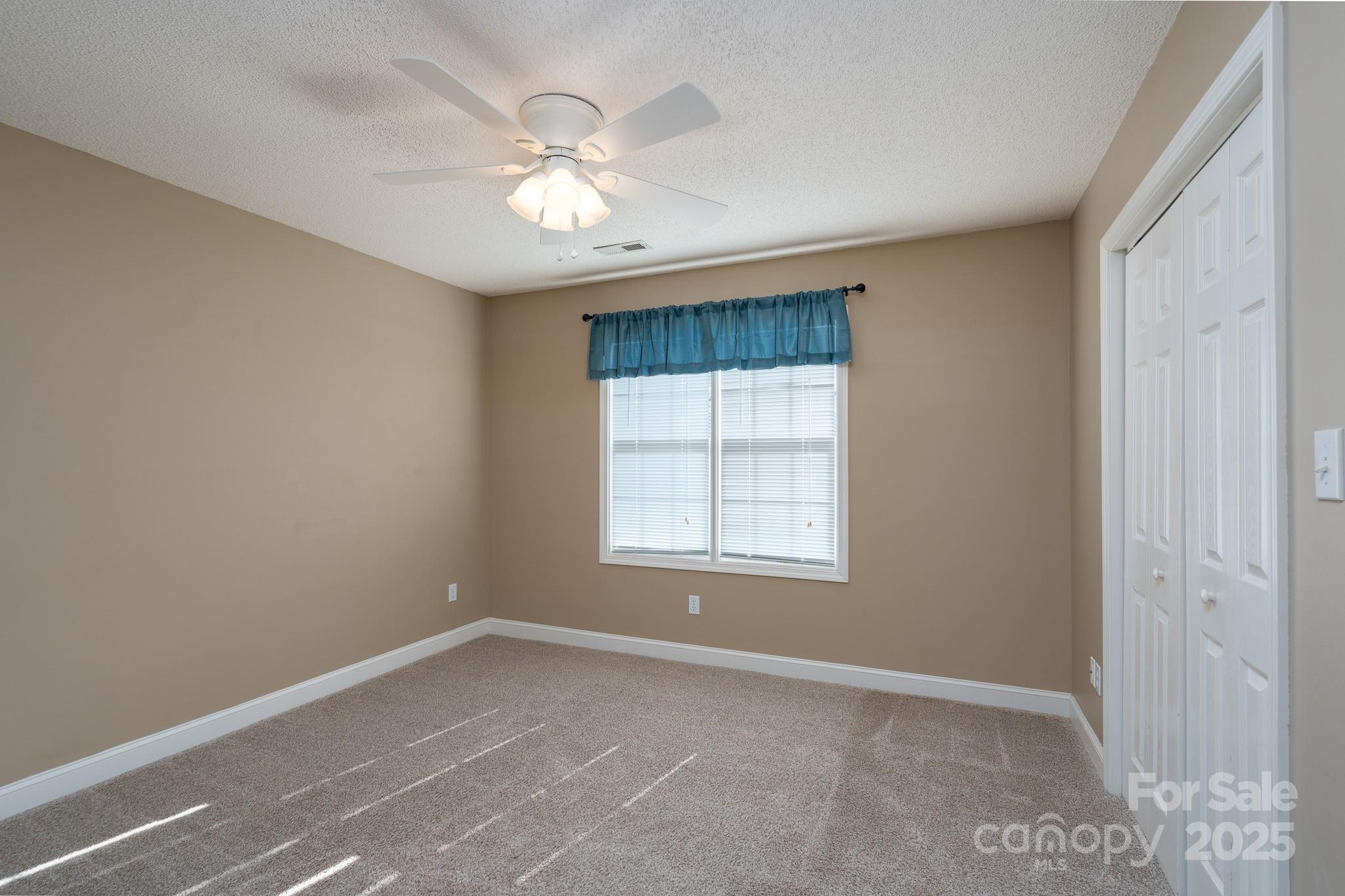 280 Bonaventure Drive Salisbury, NC 28147 - Photo 11 of 48 an empty room with chandelier fan and windows