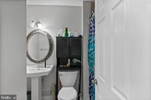 a bathroom with a toilet a sink and a mirror