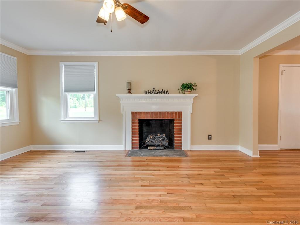 1084 Memorial Park Road Lancaster, SC 29720 - Photo 5 of 24 a view of an empty room with wooden floor fireplace and a window