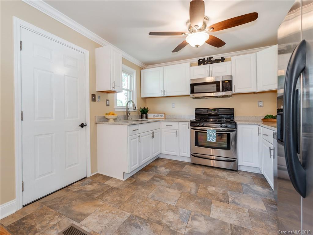 1084 Memorial Park Road Lancaster, SC 29720 - Photo 9 of 24 a kitchen with stainless steel appliances a white refrigerator a stove a sink and white cabinets