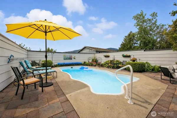 a view of a swimming pool with chair and table under an umbrella