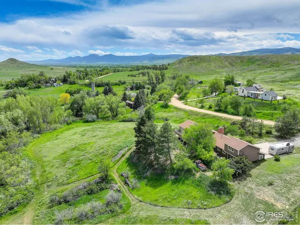 an aerial view of residential houses with outdoor space and trees