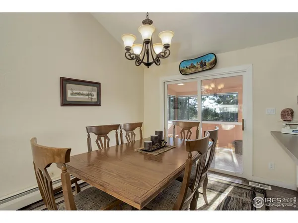 a view of a dining room with furniture a kitchen and chandelier