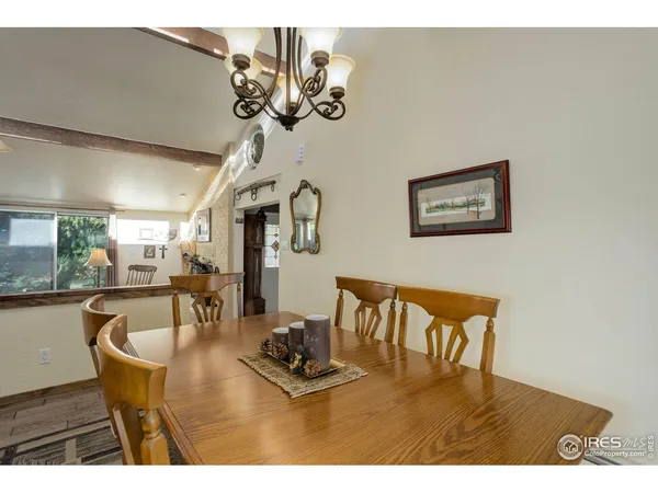 a view of a dining room with furniture a chandelier and wooden floor