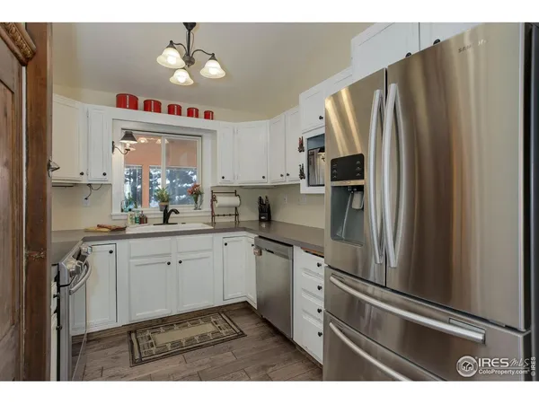 a kitchen with granite countertop a sink stainless steel appliances and cabinets
